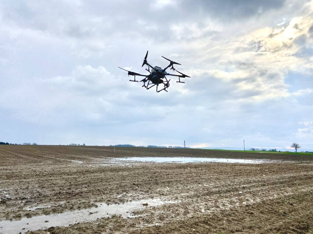 Agrardrohne ueber einem nassen, nicht befahrbaren Acker mit stehendem Wasser